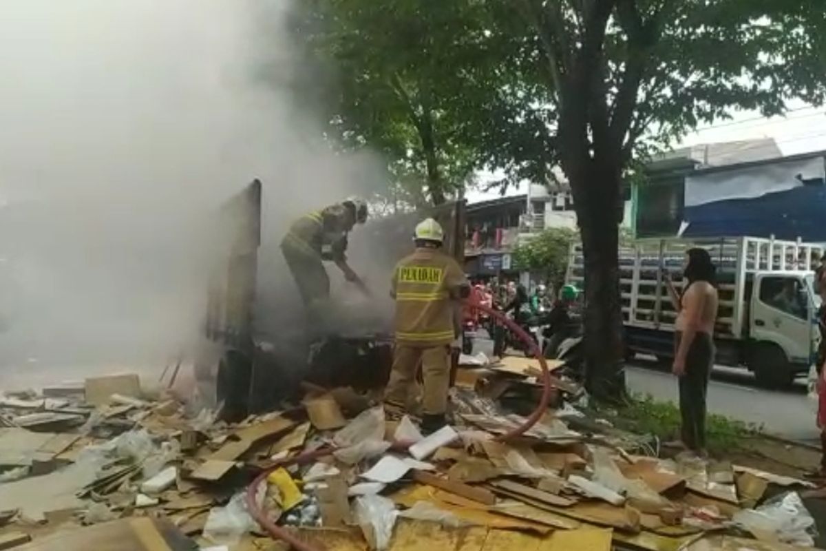 Petugas pemadam kebakaran saat memadamkan api di sebuah kendaraan bak terbuka di Jalan Rajiman Widiodiningrat, Kelurahan Terate, Cakung, Jakarta Timur, Jumat (25/11/2022). Penyebab api diduga berasal dari nyala puntung rokok. 