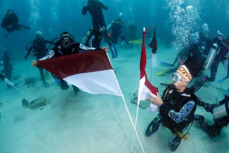 Pengibaran bendera merah putih dalam peringatan Hari Sumpah Pemuda (HSP) ke-94 dari bawah laut Tanjung Kayu Batu, Jayapura, Papua, Jumat (28/10/2022).