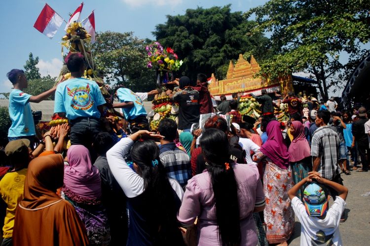 Warga Desa Sumber Jatipohon, Kecamatan Grobogan, Kabupaten Grobogan, Jawa Tengah berebut Gunungan setinggi 2,5 meter dalam tradisi sedekah bumi di obyek wisata Jatipohon, Grobogan, Kamis (9/8/2018).