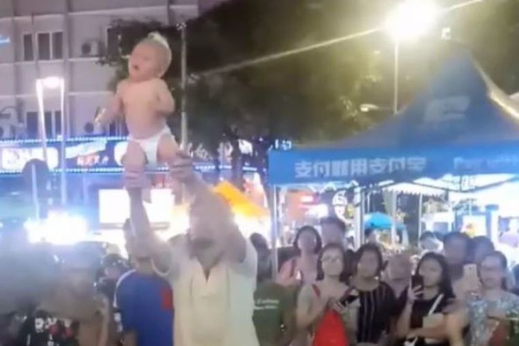 Tangkapan layar aksi turis asing di Malaysia yang melemparkan bayi sebagai bagian dari aksi jalanan mereka.