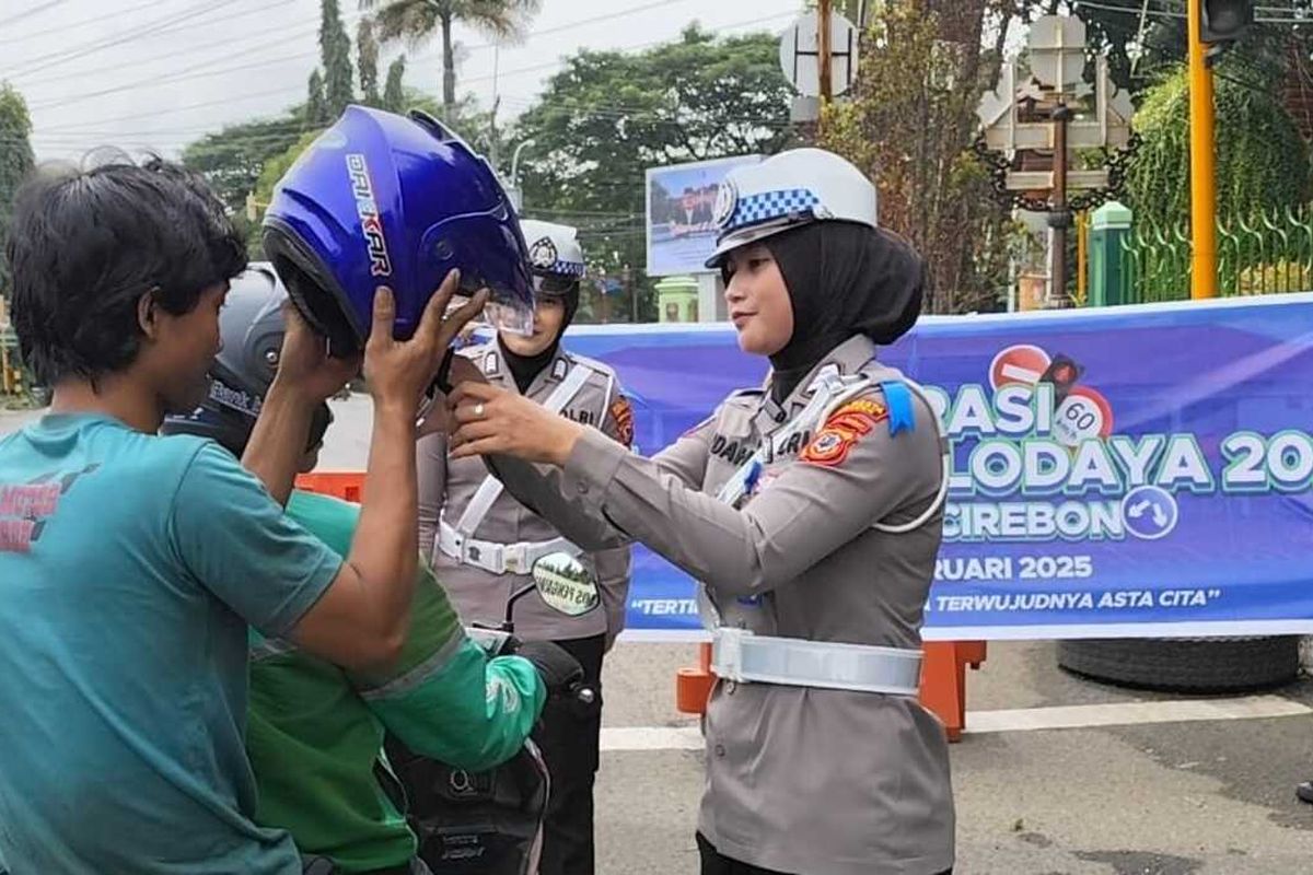 Petugas Polresta Cirebon Jawa Barat memberikan helm kepada pengendara yang tidak menggunakan helm di jalan Dewi Sartika Kecamatan Sumber Kabupaten Cirebon Jawa Barat, Senin (10/2/2025) siang.