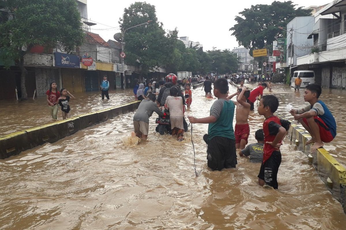 Banjir yang merendam Jalan Jatinegara Barat Raya akibat luapan Sungai Ciliwung menyebabkan sejumlah kendaraan mogok, Jumat (26/4/2019).
