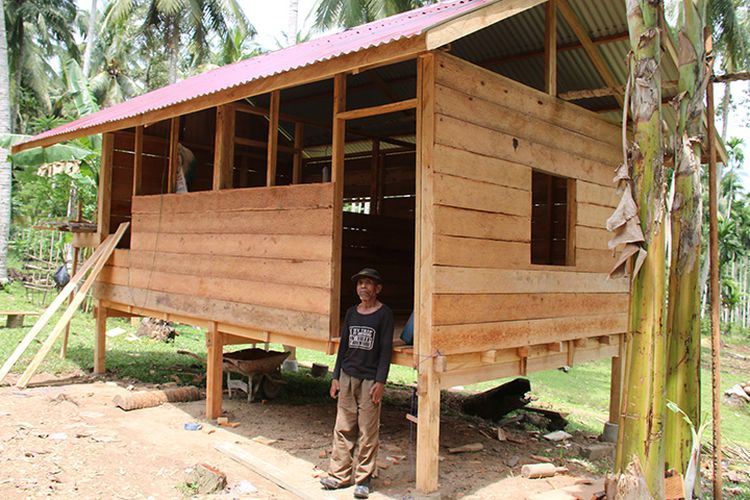 Usman (65) warga Desa Pulo Teungoh, Kecamatan Makmur, Kabupaten Bireuen, Aceh berdiri di depan rumah  panggung miliknya  yang hampir rampung dibangun oleh Bripka Deni Putra dari uang hasil mejual sepeda motor trail miliknya.