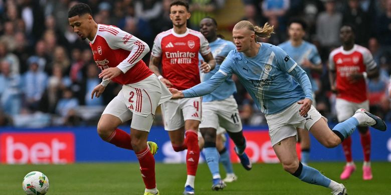 Erling Haaland (kanan) menarik baju William Saliba (kiri) dalam pertandingan sepak bola final Piala Liga Inggris antara Arsenal vs Manchester City di Stadion Wembley di London pada 22 Maret 2026. (Foto oleh Glyn KIRK / AFP) 