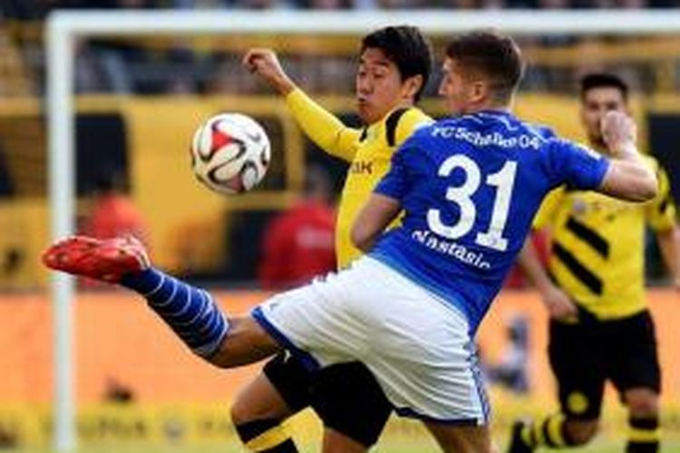 Pemain belakang Schalke (31), Matija Nastasic, berduel dengan gelandang Borussia Dortmund, Shinji Kagawa.