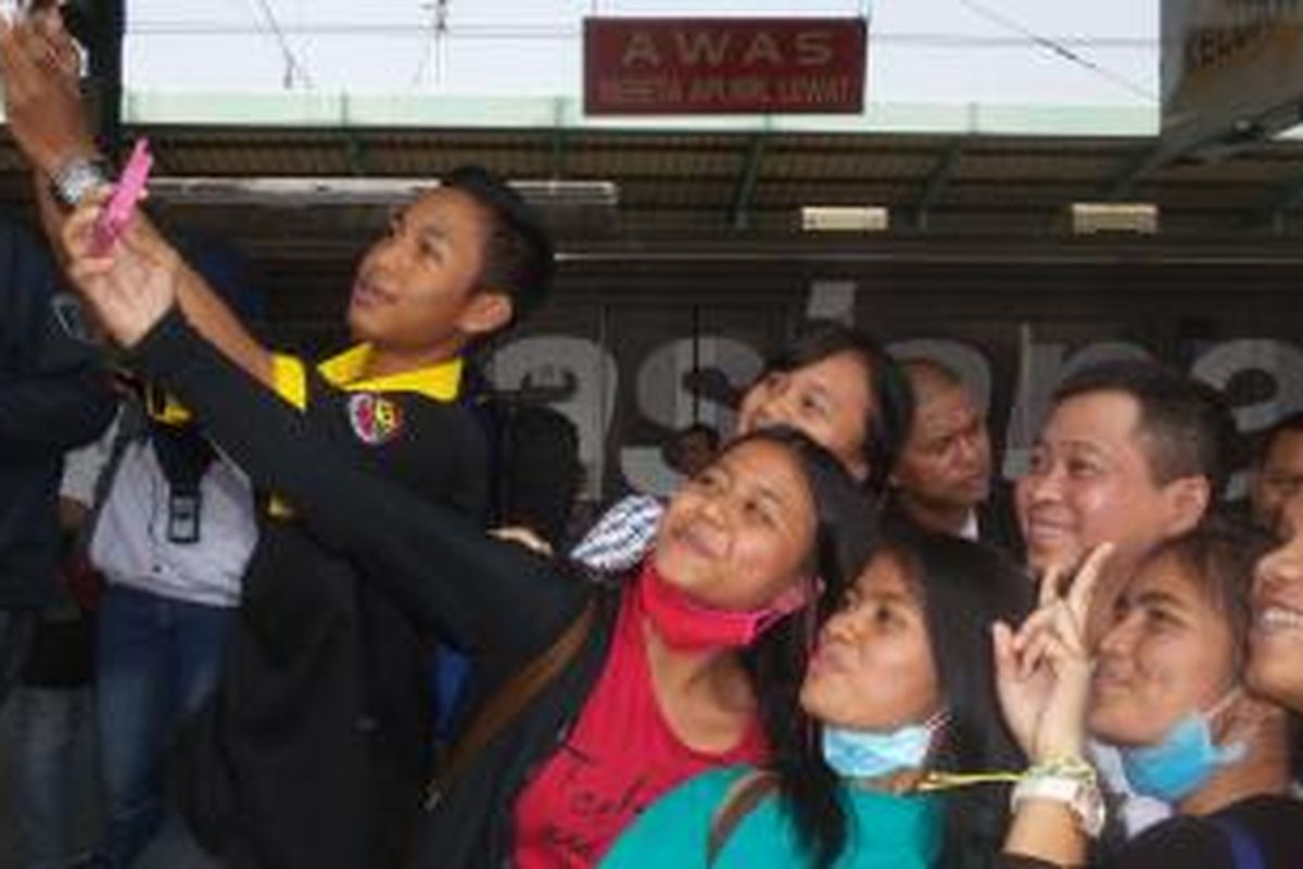 Menteri Perhubungan Ignasius Jonan saat berselfie dengan sejumlah penumpang KRL di sela-sela kunjungannya ke Stasiun Manggarai, Kamis (24/9/2015).