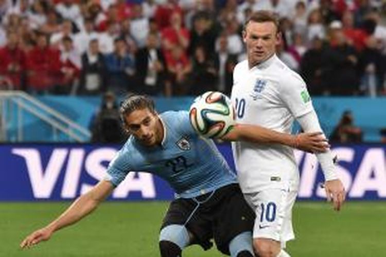 Bek Uruguay, Martin Caceres (kiri), berebut bola dengan penyerang Inggris, Wayne Rooney, pada pertandingan Grup D Piala Dunia, di Arena Corinthians, Sao Paolo, 19 Juni 2014.