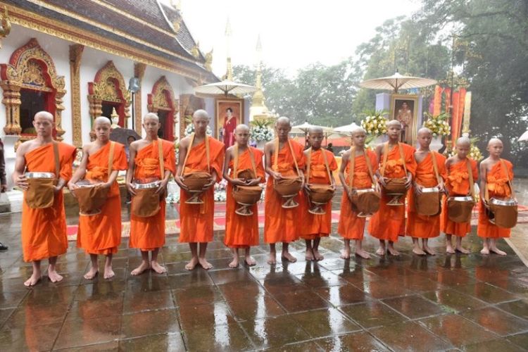 11 remaja anggota tim sepak bola Wild Boars dan pelatih Ekkapol Chantawong (kiri) ditahbiskan sebagai biksu Buddha pemula di Wihara Wat Phra That Doi Tung di distrik Mae Sai, provinsi Chiang Rai, Thailand pada 25 Juli 2018. (AFP/Panumas Sanguanwong)