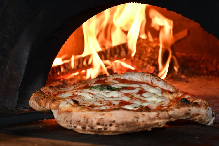 Ilustrasi memanggang pizza biasa di dalam oven tungku.