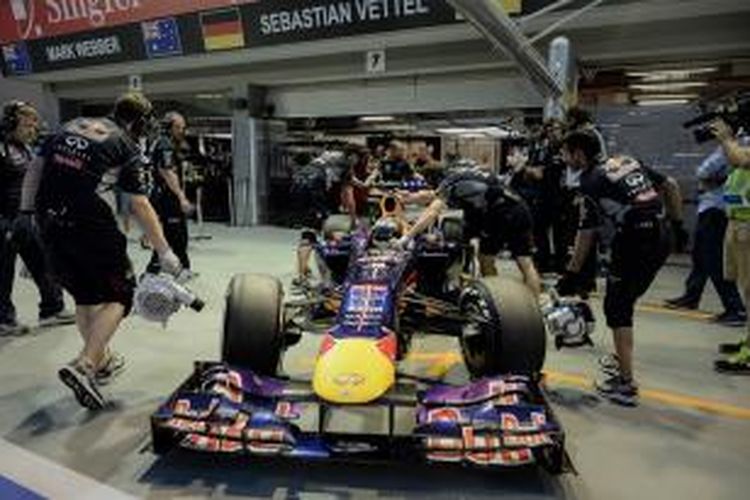 Pebalap Red Bull Racing asal Jerman, Sebastian Vettel, didorong masuk ke dalam garasi, saat menjalani sesi latihan bebas pertama GP Singapura, di Sirkuit Marina Bay Street, Jumat (20/9/2013).