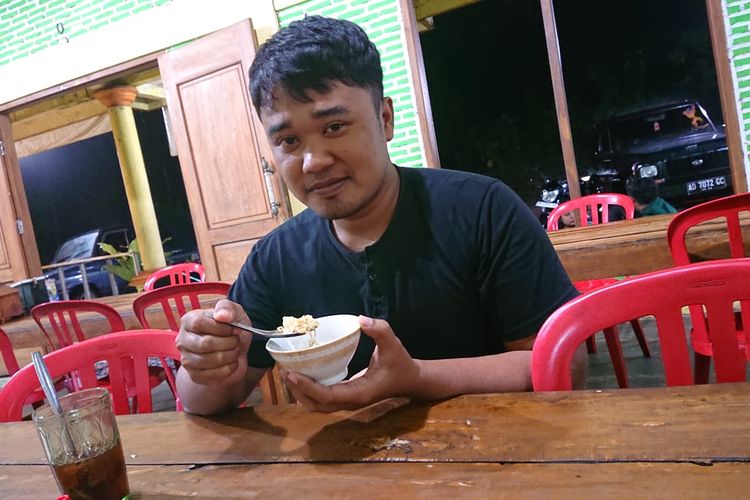 SOTO MURAH—Nandar Saputro (28), warga Desa Widoro, Kecamatan Sidoharjo, Kabupaten Wonogiri sementara menyantap malam soto murah semangkok Rp 1.000 di timur Pasar Sidoharjo,  Rabu (16/2/2023).