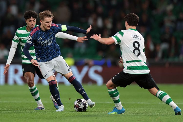 Martin Odegaard dibayangi Pedro Goncalves dan Eduardo Quaresma dalam pertandingan leg pertama perempat final Liga Champions antara Sporting CP vs Arsenal di stadion Jose Alvalade di Lisbon pada 7 April 2026. (Foto oleh PATRICIA DE MELO MOREIRA / AFP)