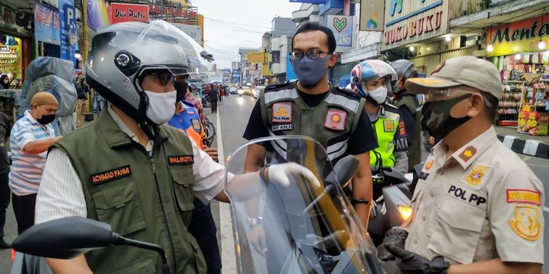 Wali Kota Sukabumi Achmad Fahmi (kiri) mengendarai sepeda motor saat berbincang dengan aparatnya dalam perjalanan pengecekan ke sejumlah wilayah di Jalan Ahmad Yani, Minggu (3/5/2020), jelang penerapan PSBB Jabar yang dimulai 6 Mei 2020. 