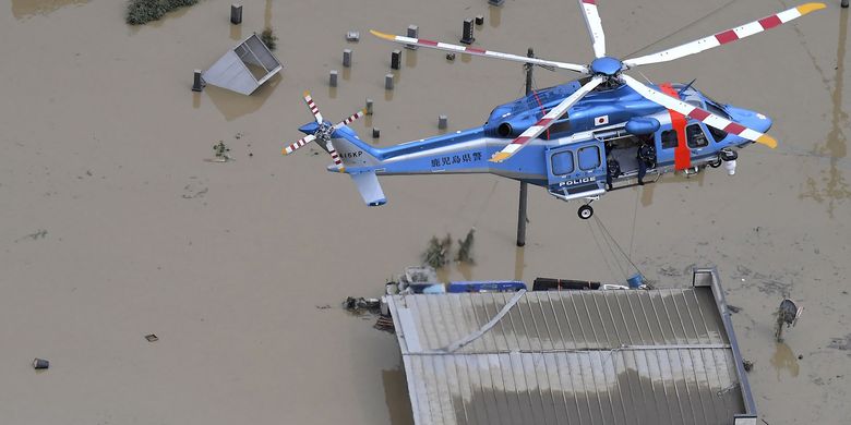 Helikopter melakukan operasi penyelamat di area terdampak banjir di Hitoyoshi, prefektur Kumamoto, Jepang, pada Sabtu (4/7/2020). Hujan deras yang mengguyur daerah tersebut memicu banjir besar dan tanah longsor, membuat belasan orang diduga tewas, beberapa orang hilang, dan puluhan lainnya terjebak di atap rumah menunggu bantuan evakuasi.