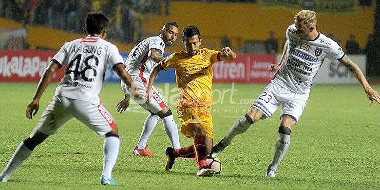 Pemain Sriwijaya FC, Manucher Dzalilov (tengah), berusaha melewati hadangan pemain Bali United pada laga leg pertama semifinal piala Presiden di Stadion Gelora Sriwijaya Jakabaring Palembang, Minggu (11/2/2018).