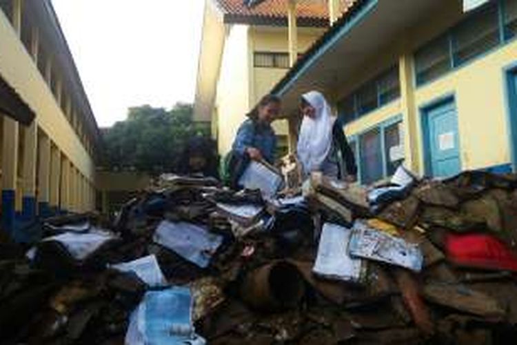 Siswa SMPN 3 Tarogong Kidul Garut sedang membereskan puing-puing bangunan dan buku rusak yang terendam banjir bandang Garut, Kamis (22/9/2016).