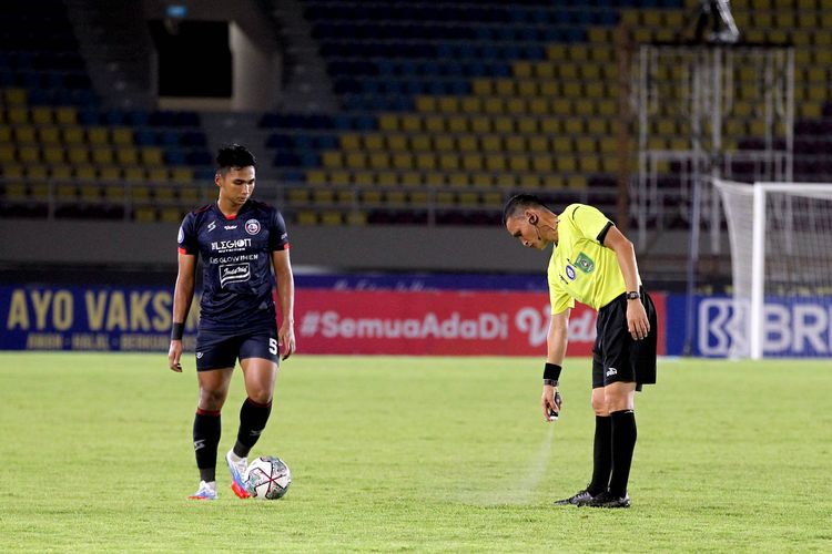 Wasit Steven Yubel Poli menyemprotkan  Vanishing Spray sebelum pemain Arema FC Bagas Adi Nugroho melakukan tendangan bebas pada pertandingan pekan 11 Liga 1 2021 melawan Persebaya Surabaya yang berakhir dengan skor 2-2 di Stadion Manahan Solo, Sabtu (6/11/2021) malam.