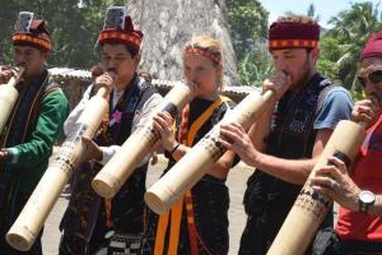 Turis meniup musik bambu Bombardom di Kampung Adat Tololela, Kabupaten Ngada, Pulau Flores, Nusa Tenggara Timur.