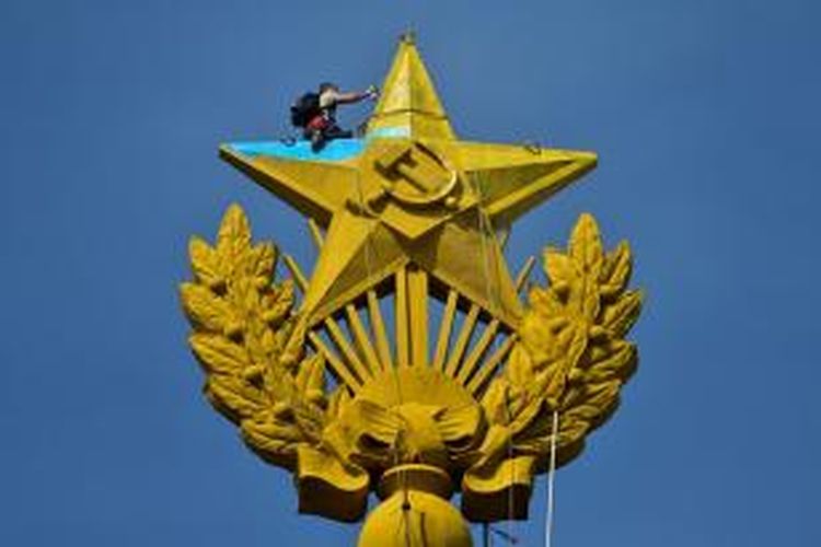 Seorang pekerja terpaksa mengecat ulang sebuah bintang raksasa di puncak sebuah gedung pencakar langit di Moskwa, Rusia setelah sebelumnya orang tak dikenal mengecat bintang itu dengan warna kuning dan biru, warna bendera Ukraina.