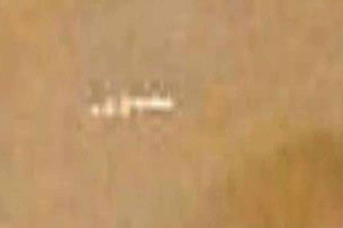 Citra objek silinder berwarna putih kabur di permukaan Mars.