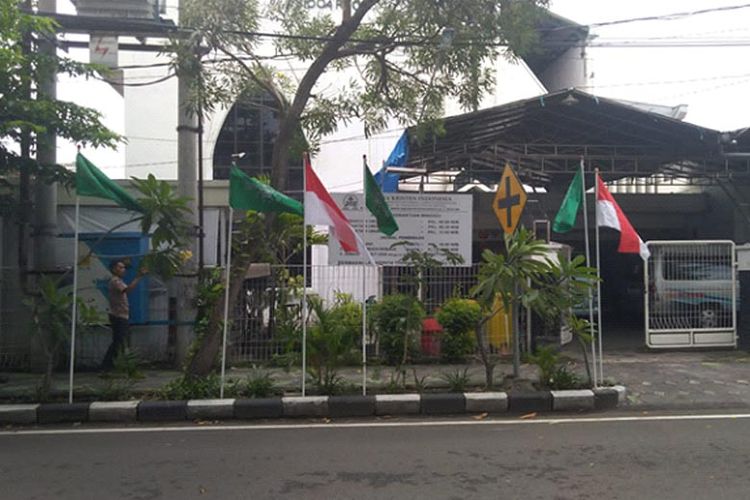 Jemaat gereja secara sukarela memasang Bendera Merah Putih dan bendera NU di depan GKI Sidoarjo untuk memeriahkan Puncak Resepsi Satu Abad NU yang digelar di Gelora Delta Sidoarjo, Selasa (7/2/2023).