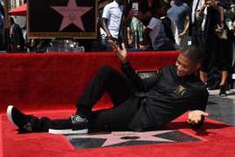Penyanyi Usher berbaring di atas bintang Hollywood Walk of Fame yang baru diterimanya di Hollywood, California, Rabu (7/9/2016).