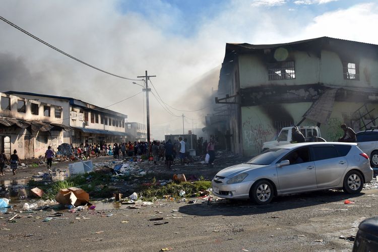 Asap membubung dari sebuah bangunan yang terbakar di ibu kota Kepulauan Solomon, Honiara, Jumat (26/11/2021). Penyebab kerusuhan di Kepulauan Solomon adalah campuran kompleks dari pengangguran kaum muda, kemarahan atas penanganan virus corona, persaingan historis antar-pulau, dan perselisihan yang membara tentang apakah Kepulauan Solomon seharusnya mengalihkan pengakuan diplomatik dari Taiwan ke China.