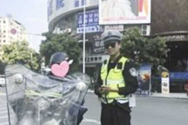 Seorang polisi di Dazhou, China, berpose dengan pelanggar lalu lintas.