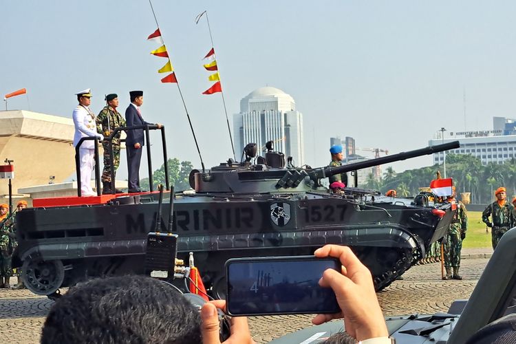 Presiden Joko Widodo menaiki tank amfibi saat memeriksa pasukan dalam upacara peringatan hari ulang tahun (HUT) ke-78 Tentara Nasional Indonesia (TNI) di Monumen Nasional (Monas), Jakarta, Kamis (5/10/2023).