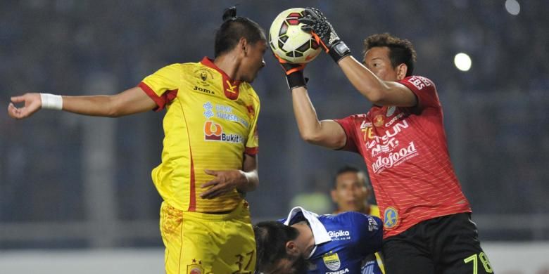 Penjaga gawang Persib Bandung I Made Wirawan (kanan) mengamankan bola dari incaran pemain Sriwijaya FC Rizsy Dwi dalam final Piala Presiden 2015 di Stadion Utama Gelora Bung Karno, Senayan, Jakarta, Minggu (18/10/2015).