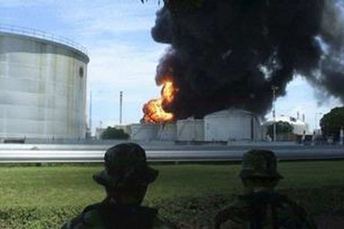 Dua orang anggota TNI mengamati api yang membubung ke angkasa yang membakar tanki bahan peningkat oktan di Komplek Pertamina Cilacap, Jawa Tengah, Sabtu (2/4/2011).