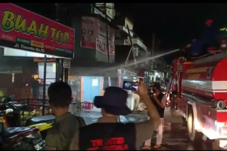 Petugas Dinas Pemadam Kebakaran Kota Makassar menyemprot kerumunan warga yang ngumpul di Warung Kopi (Warkop) Jl Barukang, Jumat (24/4/2020) malam.