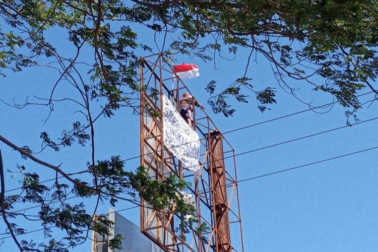 Foto: Pria yang diketahui bernama Agus nekat naik papan reklame setinggi belasan di Gelora Samador, Kelurahan Kabor, Kecamatan Alok, Sikka, Jumat (2/9/2022).