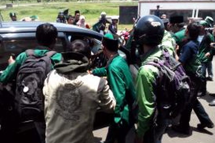 Para mahasiswa mengusir kendaraan dinas saat aksi turunkan bupati karena dugaan korupsi perjalanan dinas di depan kantor bupati Tasikmalaya, Senin (8/10/2013).