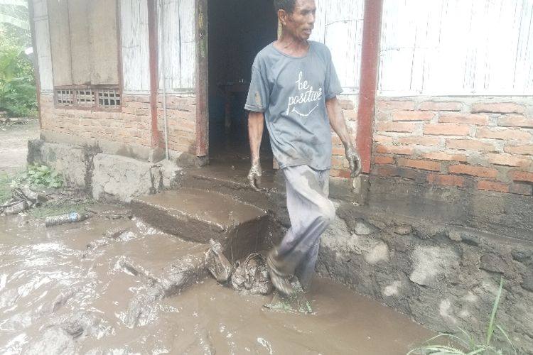 Yohanes Pama Bukan (60) warga Dusun B Tuakewiti, Desa Dulipali, Kecamatan Ile Bura, Kabupaten Flores Timur sedang membersihkan rumah yang terendam banjir lahar dingin Lewotobi Laki-laki pada Selasa (16/1/2024).