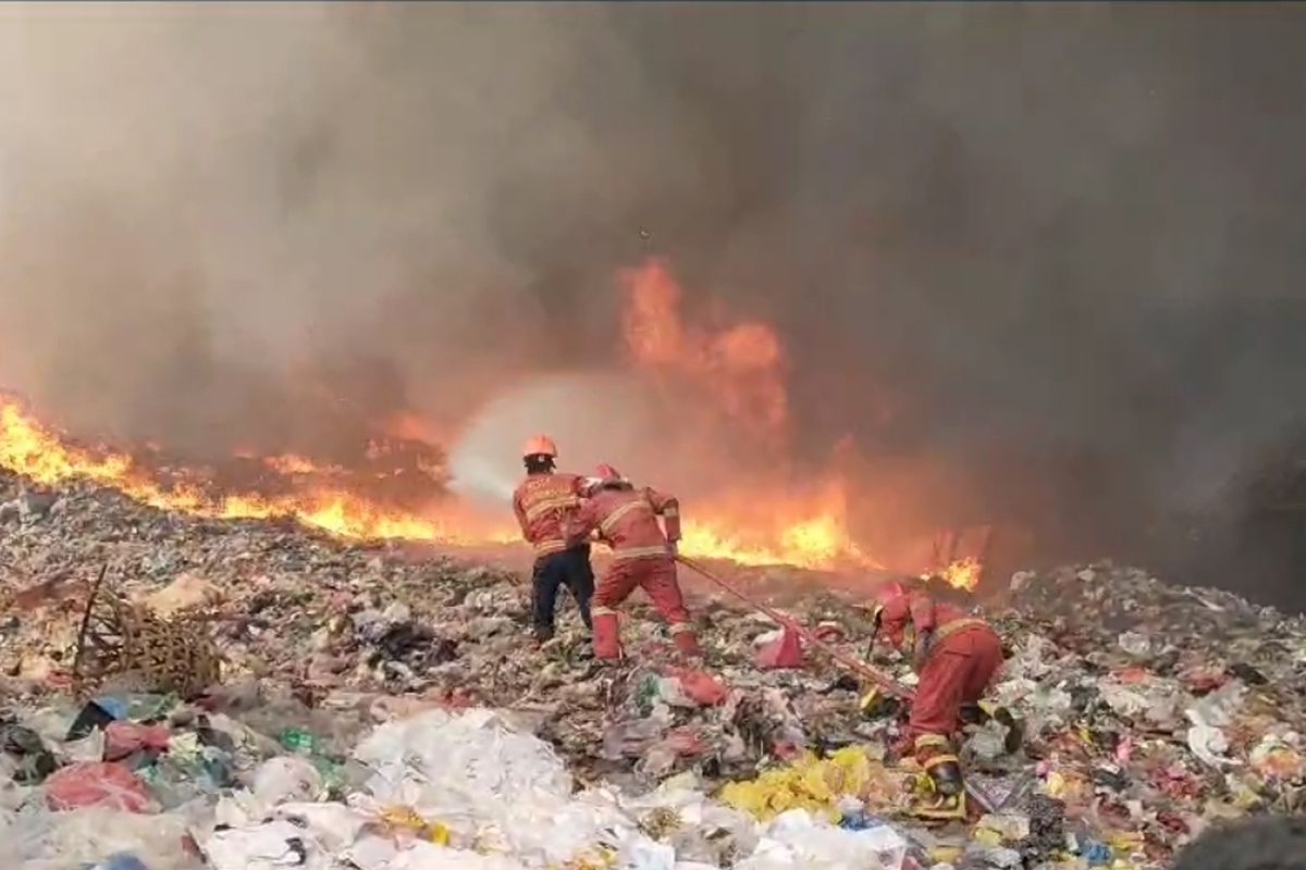 Petugas pemadam kebakaran tengah berupaya menjinakan kobaran api yang melahap TPA Rawa Kucing, Neglasari, Tangerang pada Jumat (20/10/2023).