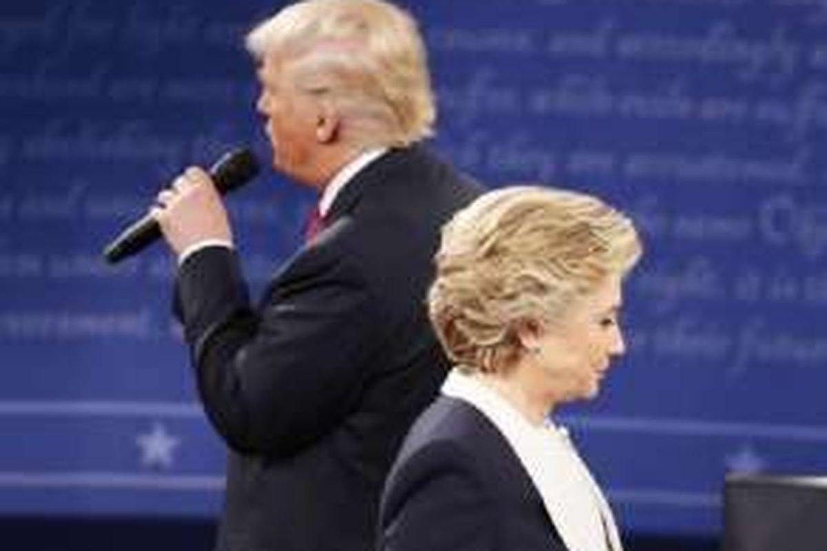 Hillary Clinton dan Donald Trump dalam debat kedua mereka sebagai kandidat Presiden AS pada Minggu (9/10/2016) malam waktu setempat di Universitas Washington, St Louis, Missouri