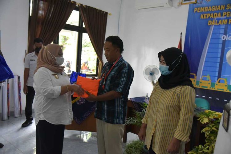 Bupati Sleman Kustini Sri Purnomo saat menyerahkan bantuan bantuan sembako dan starter kit kepada pengelola dan juru parkir. (Foto dokumentasi Humas Pemkab Sleman)