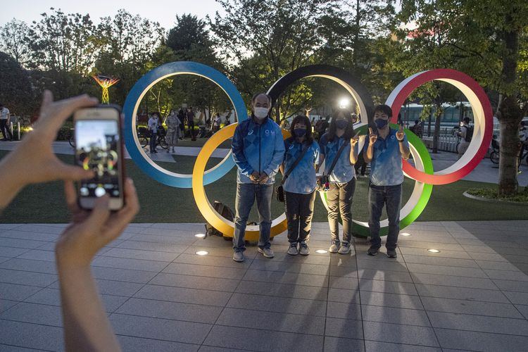 Sejumlah relawan Olimpiade Tokyo 2020 berfoto bersama di kawasan Stadion Nasional, Tokyo, Jepang, Kamis (22/7/2021). Olimpiade Tokyo 2020 bakal dibuka pada Jumat 23 Juli 2021 pukul 20.00 waktu setempat. Para pemimpin dari sekitar 15 negara dan organisasi internasional dijadwalkan hadir dalam pesta olahraga dunia yang digelar saat pandemi COVID-19 tersebut. ANTARA FOTO/Sigid Kurniawan/hp.