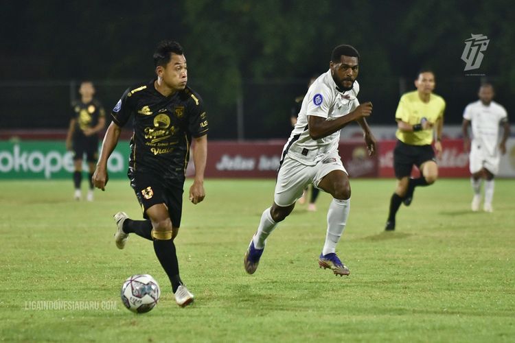 Pemain Persebaya Surabaya Samsul Arif (kiri) dijaga ketat pemain Persipura Jayapura saat pertandingan pekan 23 Liga 1 2021-2022 yang berakhir dengan skor 0-2 di Stadion I Gusti Ngurah Rai Denpasar, Minggu (6/2/2022) malam.