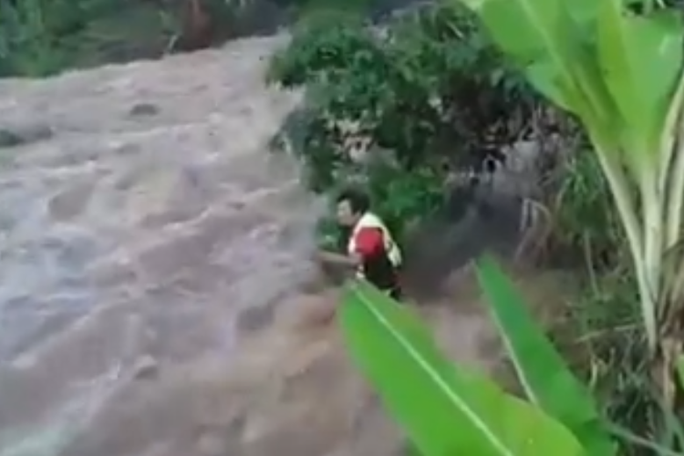 Tangkapan layar dari unggahan yang menampilkan seorang Kepala Desa di daerah Probolinggo saat menyelamatkan warganya karena terjebak banjir.