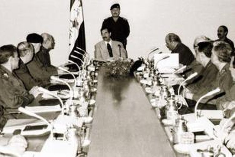 Presiden Irak Saddam Hussein, tengah, memimpin rapat gabungan Dewan Komando Revolusi dan komando regional Partai Baath yang berkuasa pada 31 Oktober 1998.
