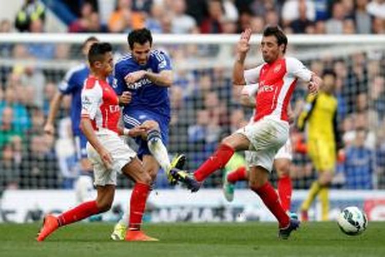 Gelandang Chelsea, Cesc Fabregas, mendapatkan hadangan dari Alexis Sanchez dan Santi Cazorla saat melawan Arsenal pada pertandingan lanjutan Premier League, Minggu (5/10/2014). 