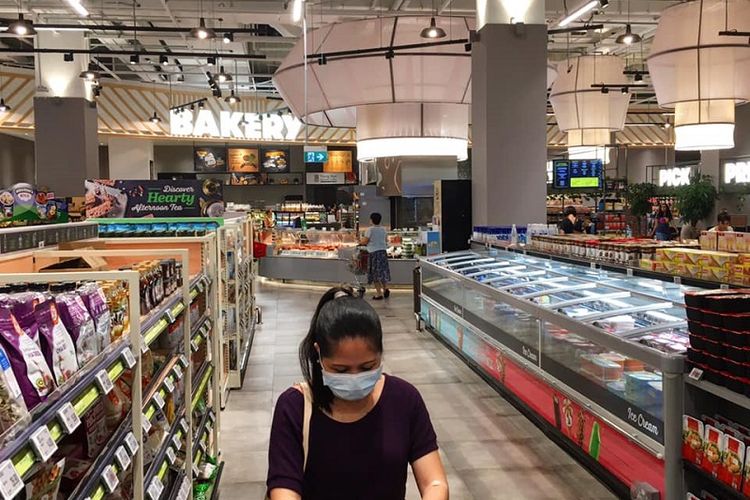 Melonjaknya kasus impor virus corona di Singapura menyebabkan kembali meningkatnya pemandangan warga yang memakai masker. Salah satunya adalah seorang wanita yang sedang mengantri untuk membayar belanjaannya di supermarket FairPrice Xtra di pusat perbelanjaan VivoCity, kawasan Harbourfront, Sabtu siang (21/03/2020)  