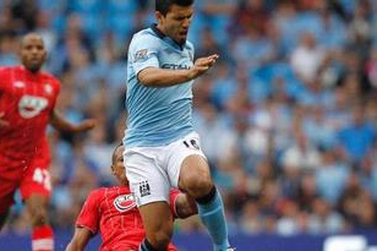 Penyerang Manchester City dari Argentina, Sergio Aguero (depan), berlari menggiring bola dan ditekel ditekel pemain Southampton, Nathaniel Clyne (kiri), dalam laga perdana Premier League 2012/13, Minggu (19/8/2012). 