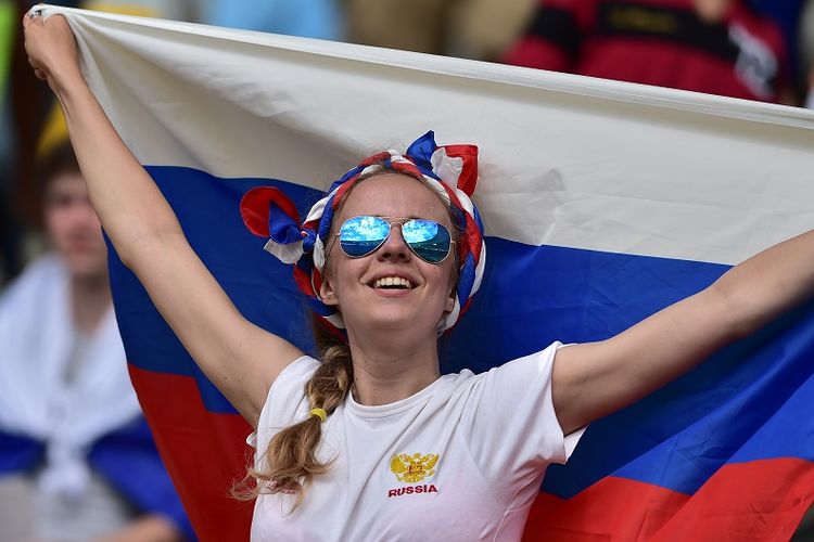 Seorang fans perempuan mengibarkan bendera Rusia sebagai dukungan terhadap tim nasional mereka yang berlaga pada Piala Dunia 2014 di Brasil.