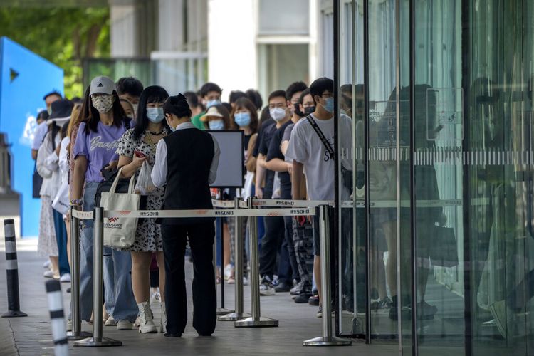 Karyawan yang mengenakan masker menunggu hasil tes COVID-19 mereka diperiksa untuk memasuki gedung perkantoran di kawasan pusat bisnis di Beijing, Selasa, 31 Mei 2022. 