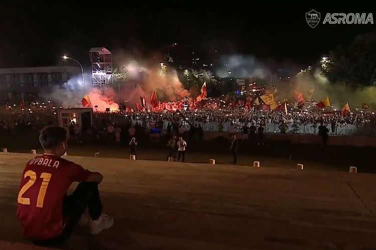 Paulo Dybala terduduk sembari mendengarkan lantunan nyanyian para fans AS Roma di acara perkenalan sang pemain di Gedung Palazzo della Civilta atau Square Colosseum, Selasa (26/7/2022).