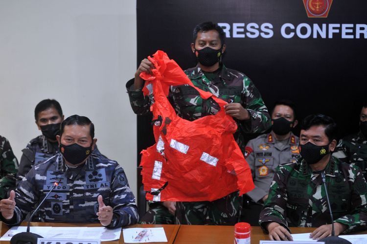 Panglima TNI Marsekal TNI Hadi Tjahjanto (kanan) dan Kepala Staf Angkatan Laut Laksamana TNI Yudo Margono (kiri) menunjukkan baju keselamatan awak kapal KRI Nanggala 402 yang ditemukan saat konferensi pers di Lanud I Gusti Ngurah Rai, Badung, Bali, Minggu (25/4/2021). KRI Nanggala 402 dipastikan tenggelam dan 53 awak kapalnya gugur di perairan utara Bali. ANTARA FOTO/Fikri Yusuf