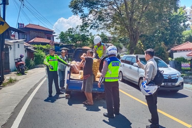 Wadirlantas Polda Jabar bersama anggotanya menggotong mobil bak terbuka yang mogok karena patah as roda belakang di jalur mudik Limbangan, Minggu (7/4/2024)
